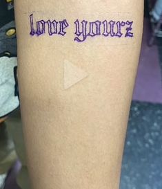 the word love you more written on someone's leg with an arrow in purple ink