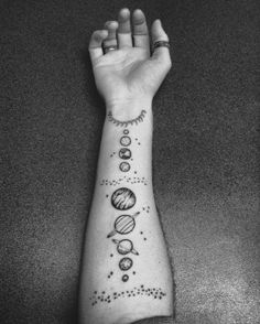 a person's arm with different planets and stars tattooed on the side of it