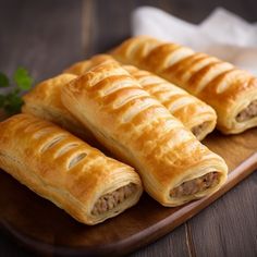 three sausage wrapped in bread on a cutting board