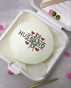 a cake with the words husband and wife on it in a plastic container, surrounded by confetti