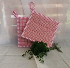 two red and white gingham cloths sitting next to each other on a table