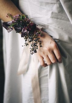 a close up of a person's arm wearing a flower bracelet with flowers on it