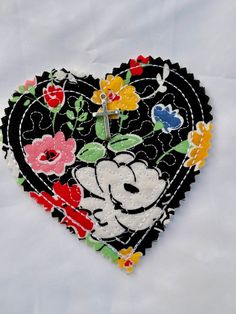 a heart shaped clock with flowers painted on it