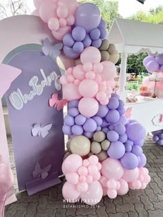 a number made out of balloons sitting on top of a brick floor next to a table