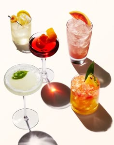 four different types of cocktails sitting on a table