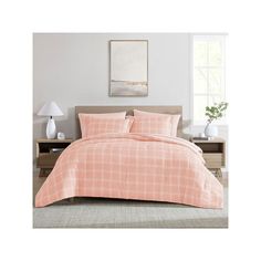 an orange and white plaid comforter set on a bed