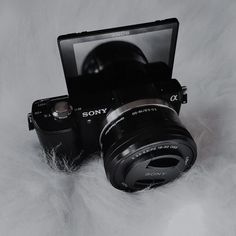 a sony camera sitting on top of a white fur covered floor