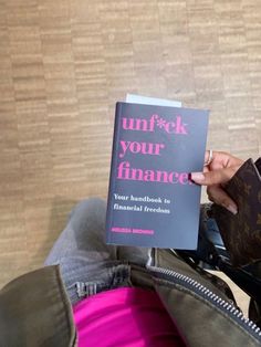 a person holding up a book in their hand with the title unlock your finance written on it