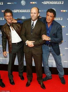 three men standing next to each other in front of a red carpet with the words expeniales on it