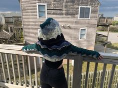 a woman standing on a porch next to a house