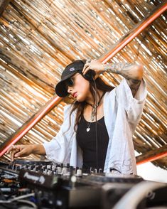 a woman with headphones and a dj's turntable in front of a bamboo wall