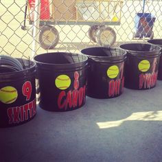 several buckets with tennis balls painted on them