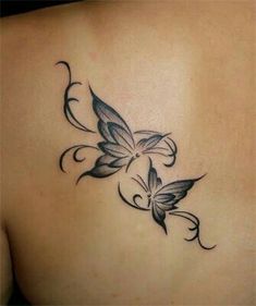 a woman's back with a butterfly tattoo on it