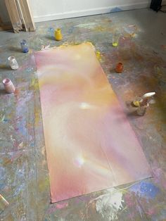 a painting is being worked on in an art studio with paint and supplies scattered around