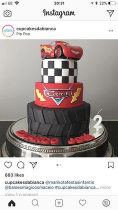 a cake made to look like a race car on top of a pile of tires