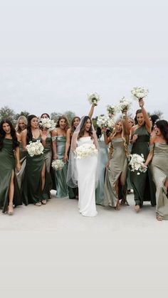 a group of women standing next to each other holding bouquets in front of them