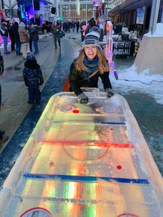 a woman standing next to an ice hockey table