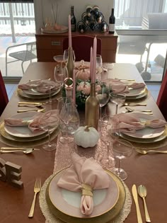 the table is set with pink and gold place settings