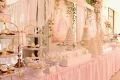 a long table covered in lots of cakes and cupcakes