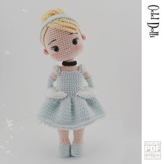 a crocheted doll is wearing a blue dress