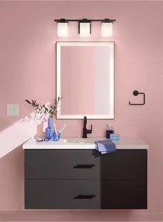 a bathroom with pink walls and black vanity, white sink and mirror on the wall