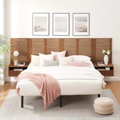 a white bed sitting in a bedroom on top of a wooden floor