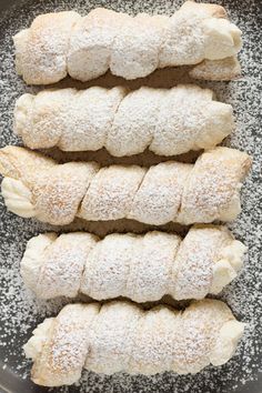 four pieces of bread sitting in a frying pan with powdered sugar on top