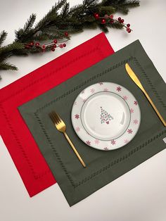 the place setting is ready to be eaten with goldware and christmas tree napkins