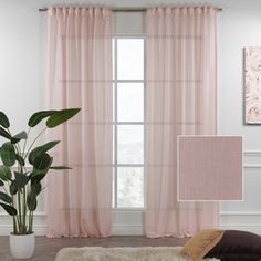 a living room with pink curtains and a plant in front of the window on a rug