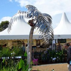 a palm tree made out of metal is in the middle of an outdoor garden show