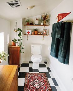 a white toilet sitting in a bathroom next to a black and white checkered floor