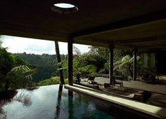 an outdoor swimming pool with lounge chairs and trees in the background, surrounded by greenery