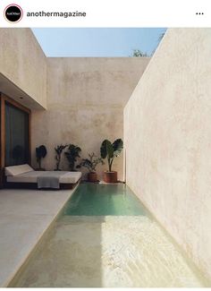 an indoor swimming pool in the middle of a room with concrete walls and flooring