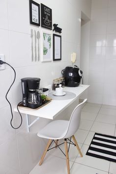 a kitchen with white tile and black accents on the wall, along with two chairs