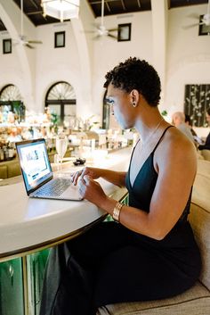 a woman sitting at a table using a laptop computer