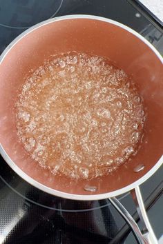 a frying pan filled with boiling water on top of a gas burner oven