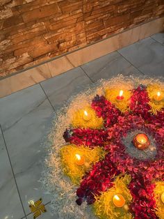 a circular arrangement of flowers and candles on the ground