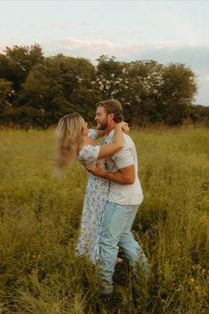 a man and woman standing in tall grass