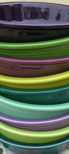 a stack of colorful plates sitting on top of each other in front of a wall