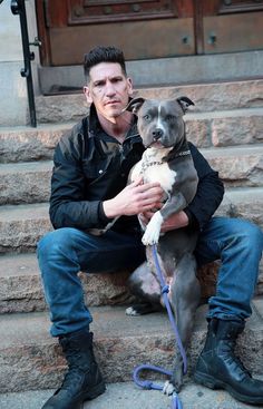 a man sitting on the steps with his dog