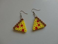 a pair of earrings made to look like a slice of pizza on a white surface