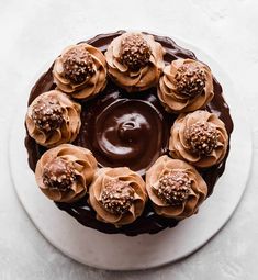 a cake with chocolate frosting and flowers on top is sitting on a white plate