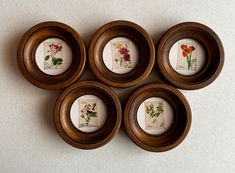 four wooden bowls with flowers painted on them