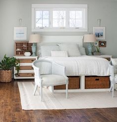 a bedroom with white bedding and two wicker baskets on the wall above it