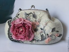 a white purse with a pink flower on it