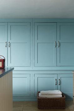 a kitchen with blue cabinets and white counter tops