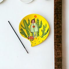 a yellow plate with an image of a woman on it next to some chopsticks