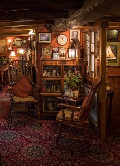 a living room filled with lots of furniture next to a wall covered in pictures and clocks