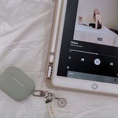 an electronic device with a keychain attached to it sitting on a white sheet