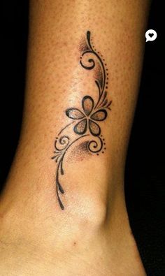 a woman's foot with a tattoo design on the bottom of her leg,